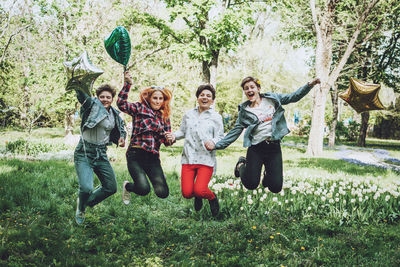 Full length of a smiling young woman against plants