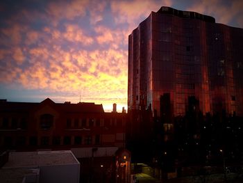 Buildings against cloudy sky at sunset