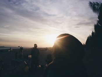 Silhouette people standing against sky during sunset