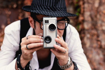 Close-up of creative man recording with 8mm video camera.