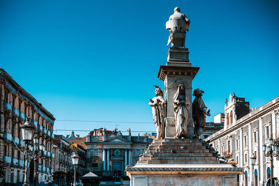 Low angle view of statue against buildings