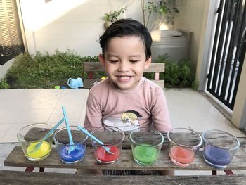 Portrait of smiling boy with drink on table