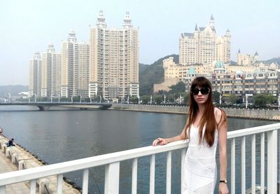 Portrait of young woman standing by river