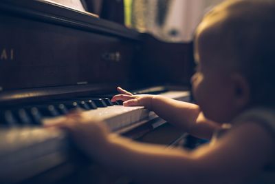 Close-up of baby girl playing piano at home