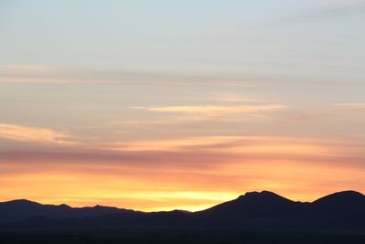 Scenic view of silhouette mountains against sky during sunset