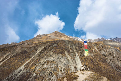 Prayer flags on rocky mountains against sky