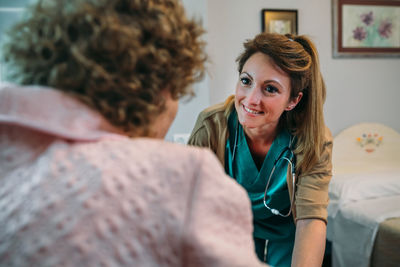 Female doctor talking with senior patient in hospital