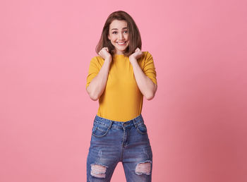 Portrait of a smiling young woman against gray background