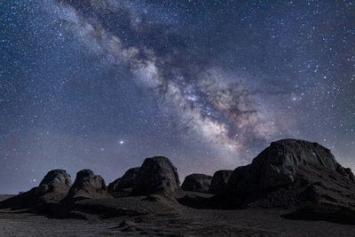 Scenic view of rock formation against sky at night