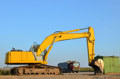 Crane at construction site against clear blue sky