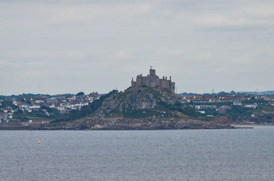 Distant view of town against cloudy sky