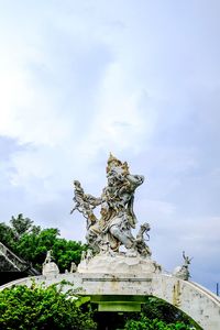 Low angle view of statue on building against sky