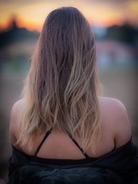 Rear view of woman looking at view of sunset