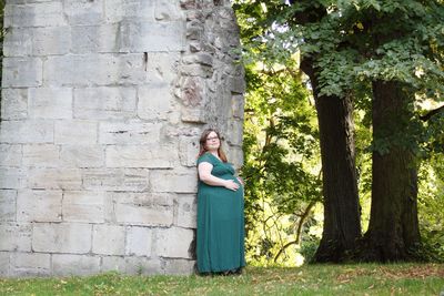 Portrait of woman standing against tree