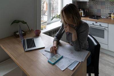 Woman designer using smartphone, takes a break from work and listens to speaker in club house