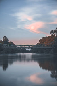 Bridge over river against sky during sunset