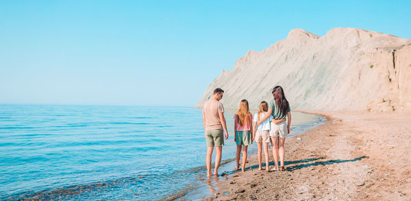 People standing at beach against sky