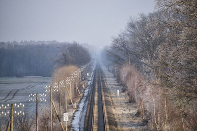 View of railroad tracks against clear sky during winter