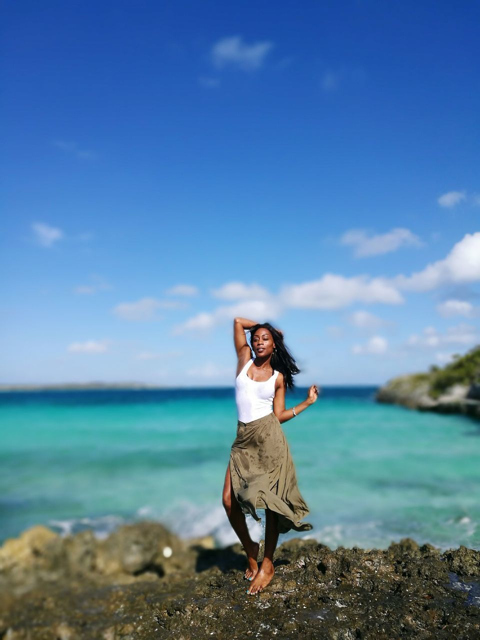 sea, nature, one person, full length, sky, water, standing, beauty in nature, horizon over water, real people, leisure activity, scenics, rock - object, outdoors, day, front view, cloud - sky, young adult, lifestyles, young women, tranquil scene, beautiful woman, posing, blue, beach, vacations, smiling, people