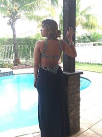 Rear view of woman standing by swimming pool