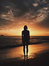 Silhouette of people on beach at sunset