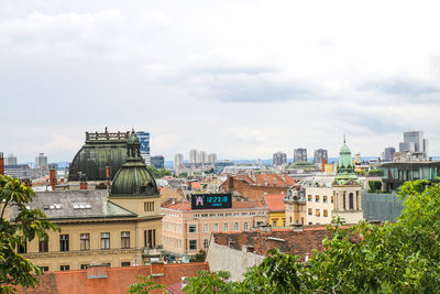 Buildings in city against cloudy sky