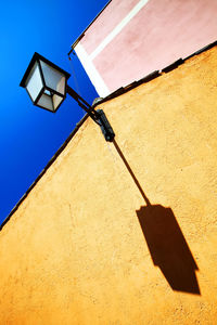 Low angle view of lantern on building against clear blue sky