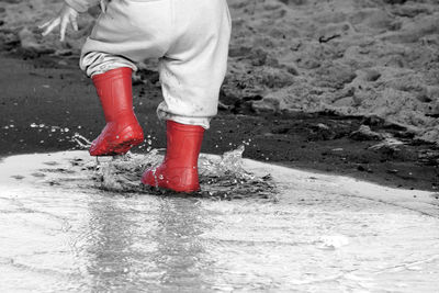 Low section of child on wet road during rainy season