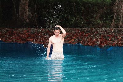 Young man standing in swimming pool