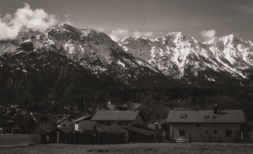 Houses by trees and mountains against sky