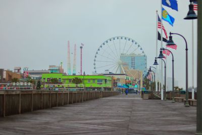Amusement park by sea against sky