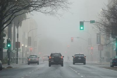 Cars on road in city during winter