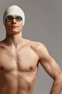 Portrait of shirtless man standing against white background