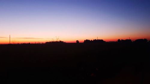 Silhouette landscape against clear sky at sunset