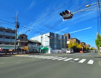 Cars on road against sky in city