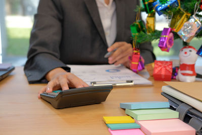 Midsection of businessman working on table during christmas