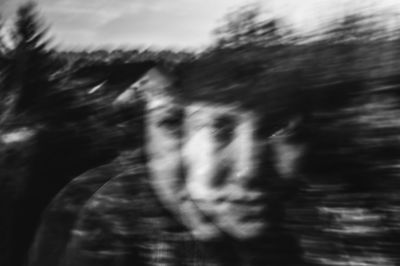 Close-up portrait of woman against blurred plants