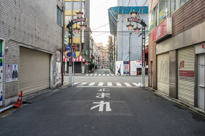 Road sign on street amidst buildings in city