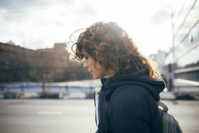 Portrait of young woman looking at city in winter