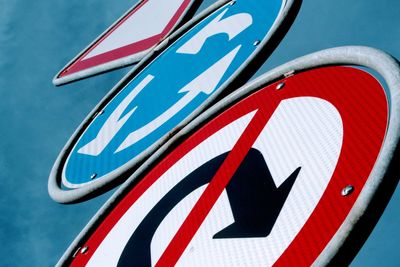 Low angle view of road sign against blue sky