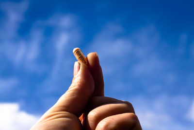 Low angle view of human hand against sky