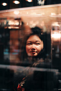 Young woman looking away seen through glass