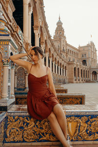 Rear view of woman standing against building