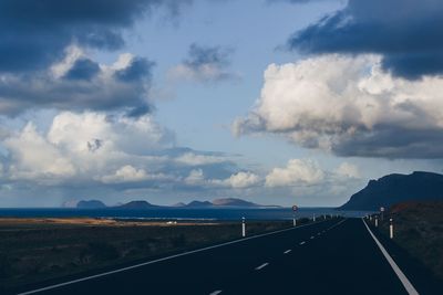 Road leading towards mountain against sky