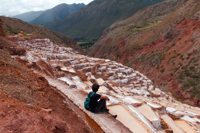 High angle view of man sitting on cliff