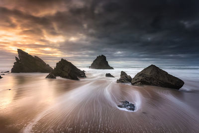 Rocks on beach against sky