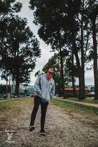 Full length of man standing on footpath amidst trees