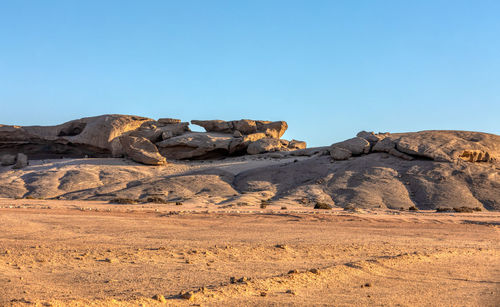 Rock formations in desert against clear blue sky