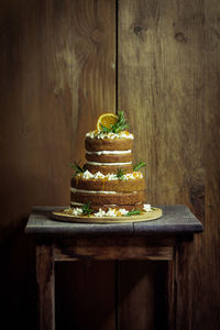 Cake on wooden table against wall