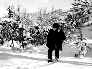 Rear view of woman standing on snow covered landscape